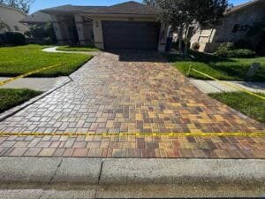 a brick driveway with yellow tape